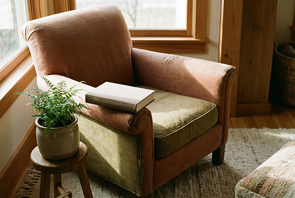A worn leather armchair by a window with an open book on the seat and a potted fern alongside — on inner life and knowing what you actually want, with Ellie James